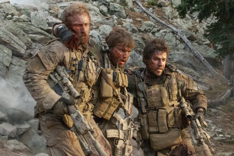Where to watch Lone Survivor scene still showing an intense combat moment from the movie in rugged terrain