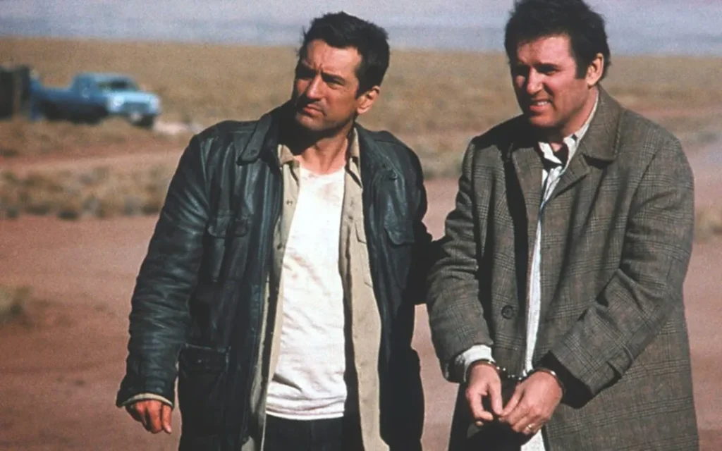 Where to Watch Midnight Run scene still showing a tense but funny moment with the main characters during their road trip